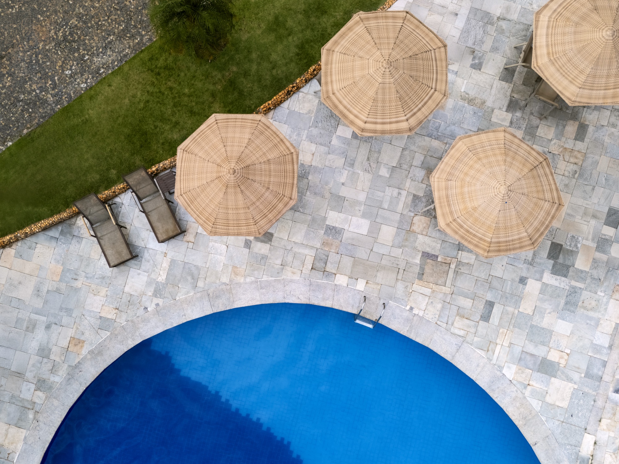 Guarda-sóis e piscina vista de drone